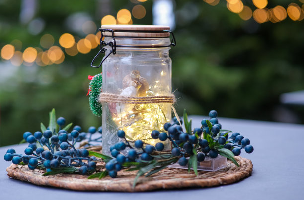 大气的圣诞装饰室外LED仙女灯在一个玻璃与星星，蝴蝶结和浆果图片下载