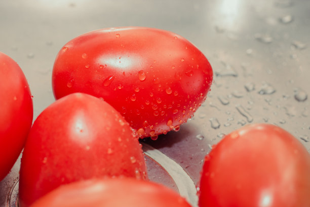 特写湿番茄与水滴。照片里的红色水果在水槽里洗图片下载