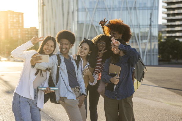 一群多种族学生在大学校园里自拍，用手做和平符号。关注非裔美国男孩图片下载