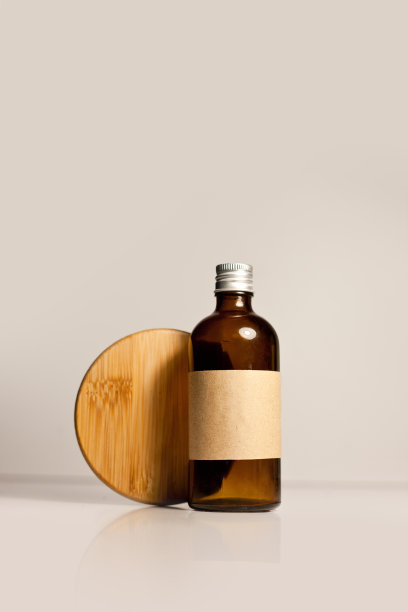 一个化妆品暗琥珀色玻璃瓶与牛皮纸标签，极简主义品牌包装模拟图片下载