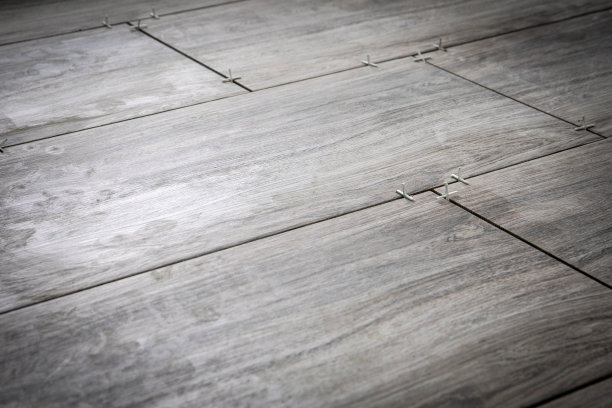 翻新或修复概念。用塑料十字架铺设瓷砖图片下载