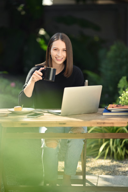加拿大白人妇女坐在户外咖啡店，看着相机。图片下载