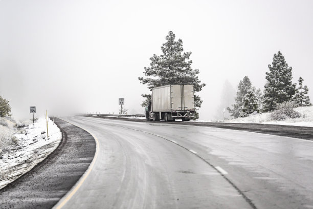 破损的大钻机半挂车开罩和干式货车半挂车站在蜿蜒的冬季道路上与降雪等待拖在移动维修道路服务图片下载