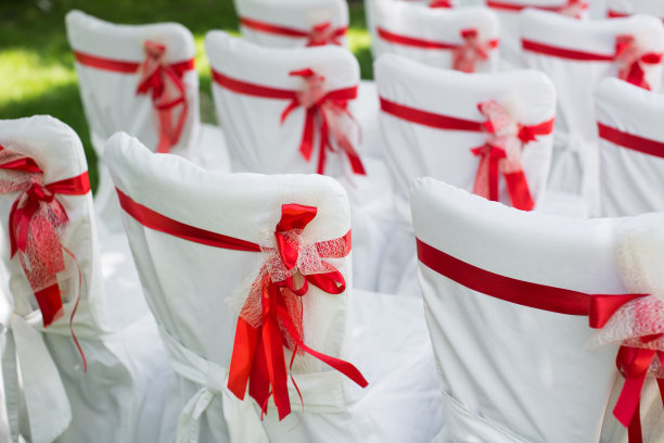 户外婚礼。白椅子配红丝带。图片下载