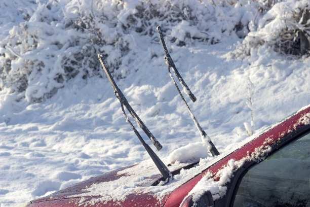汽车的雨刷是抬高的，这样它们就不会冻结在窗户上。冬天汽车里凸出的雨刷图片下载