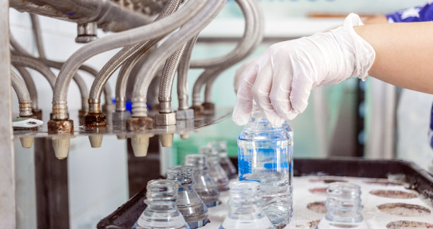 质检员的手水装瓶线处理和装瓶纯饮用水图片下载