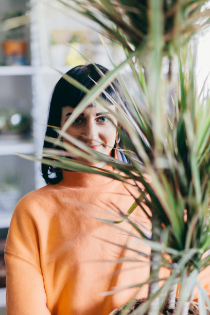 花店里有一株绿色大植物的女人图片下载