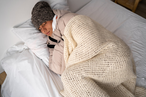 欧洲能源危机。一个男人在卧室睡觉时冻僵了。家庭取暖用天然气价格上涨。电力危机，供暖问题图片下载