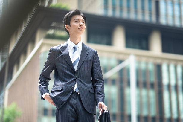 一个西装革履的男人走在商业区图片下载