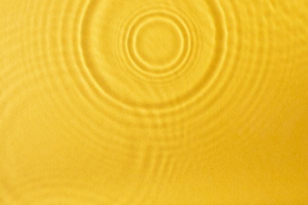 水表面的纹理。黄色背景。图片下载