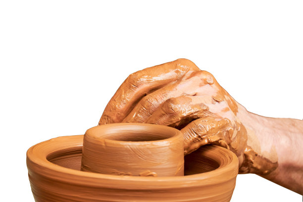 一个穿着中世纪拜占庭旧衣服的男人坐在老式制陶轮后面，在白色背景上用粘土制作盘子。复古风格的陶器。图片下载