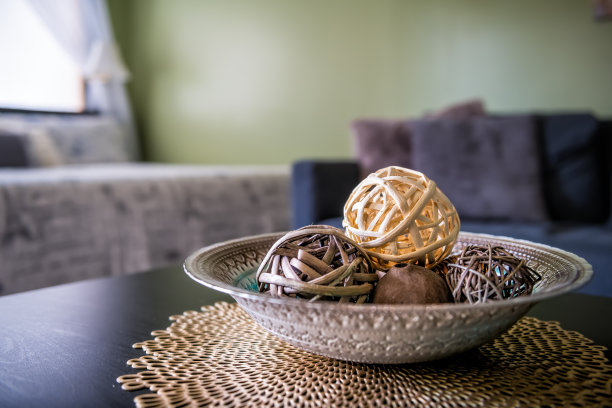 现代当代干净的装饰柳条球在桌子上的餐垫垫在公寓家庭或房子明亮的光线从窗户，沙发沙发图片下载