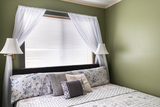 卧室房间有灯，枕头，床垫上的床单床床头板，现代酒店汽车旅馆房间，白色窗帘和绿色墙壁图片下载