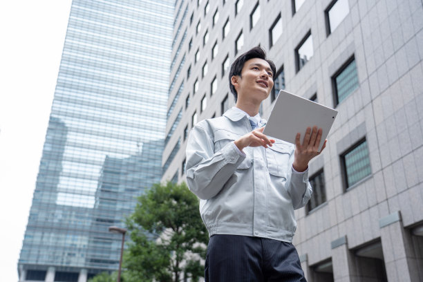 一个穿着工作服的男人在操作平板电脑图片下载