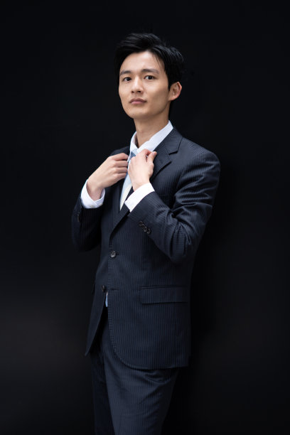 一个日本商人的肖像对着一堵黑色的墙图片下载