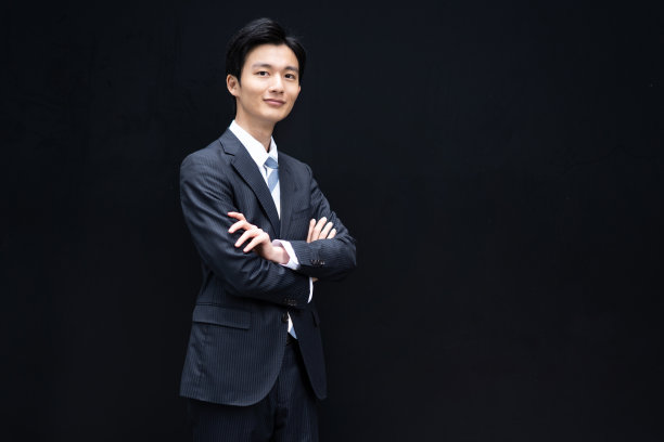 一个日本商人的肖像对着一堵黑色的墙图片下载