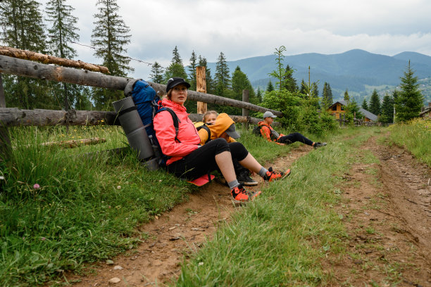 一家人在山上远足时坐下来休息的照片。图片下载