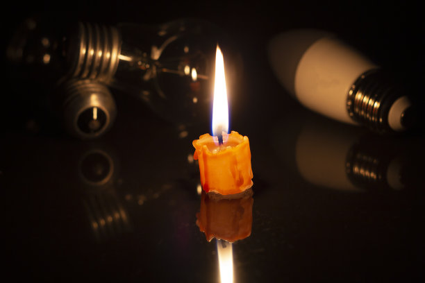在完全黑暗的情况下，关掉灯或不发光的灯泡，靠近燃烧的蜡烛。图片下载