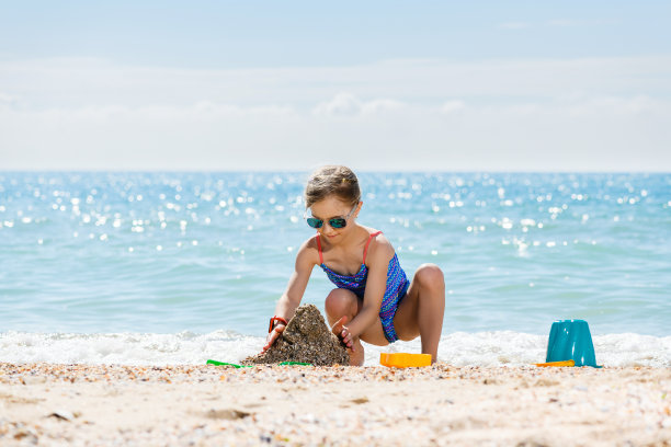 小女孩在海滩上玩沙子图片下载
