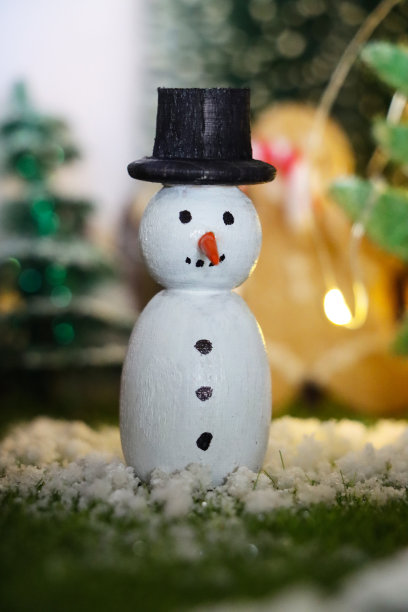 特写图像的木制雪人节日自制圣诞装饰在风景圣诞村展示在橱柜顶部，人造塑料圣诞树，照明自制木屋，重点在前景图片下载