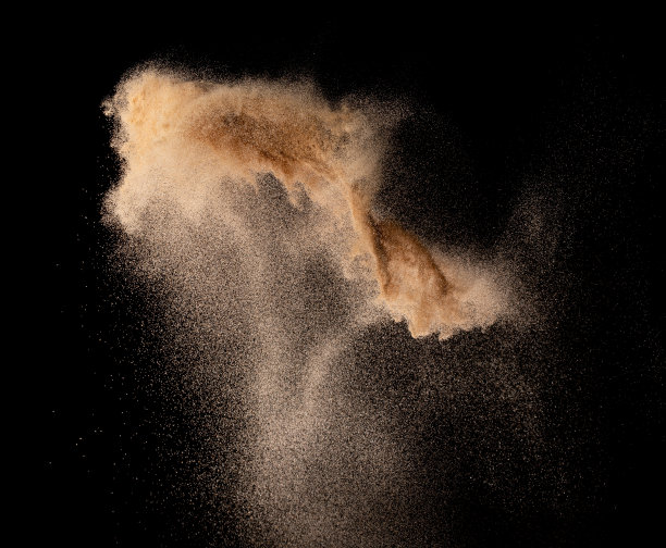 小粒细沙飞爆，金粒波爆。抽象的云飞。黄色砂在空气中飞溅二氧化硅。黑色背景隔离高速快门，抛出定格镜头图片下载