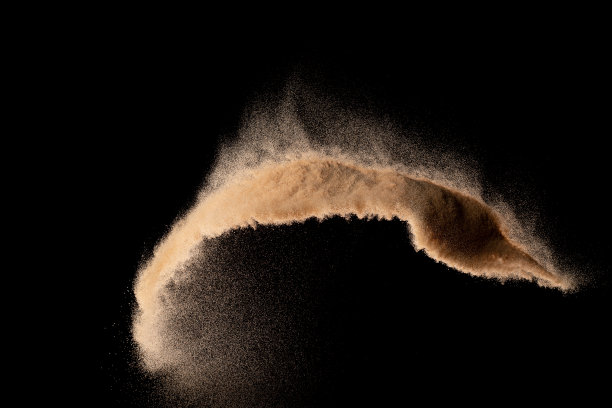 小粒细沙飞爆，金粒波爆。抽象的云飞。黄色砂在空气中飞溅二氧化硅。黑色背景隔离高速快门，抛出定格镜头图片下载