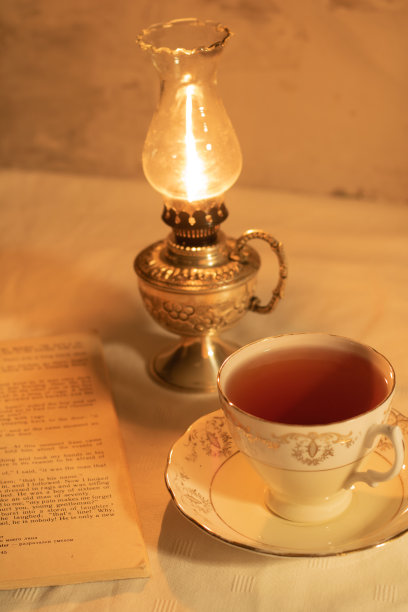 一杯茶，一本书，旁边是一盏煤油灯图片下载