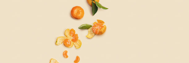 橘黄色多汁的橘子与绿色的叶子，整体和剥皮的中性米色背景，俯视图宽横幅与空白。柑橘类水果桔子，水果美食创意照片图片下载