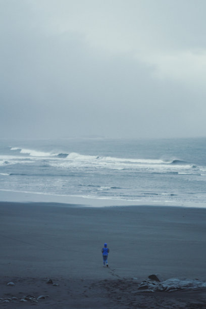 女子走在黑色海滩风景照片图片下载