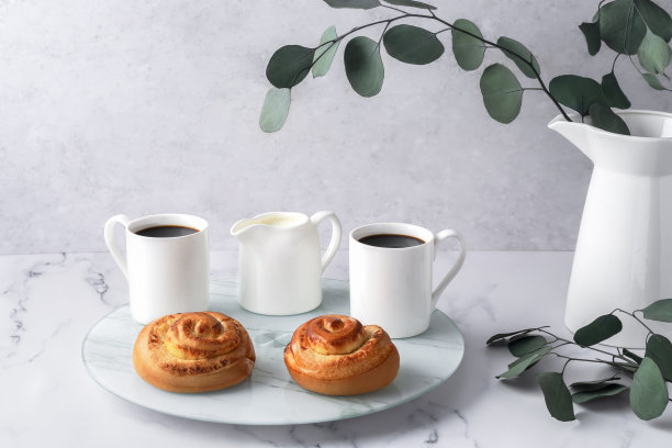 瑞典平衡生活理念，Lagom。舒适的早晨，咖啡，面包，玻璃托盘上的送奶员。白色花瓶和桉树树枝放在大理石桌子上。水平复制空间。图片下载