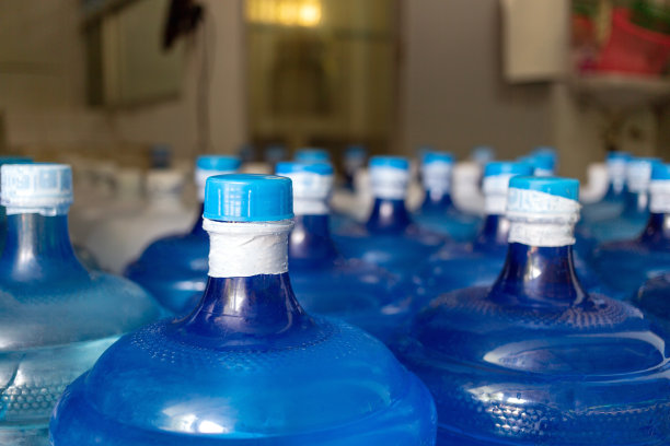 装有饮用水的蓝色水加仑已经用塑料密封密封在饮用水厂等待运送图片下载
