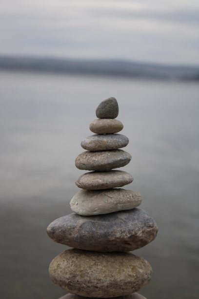 海滩上的一堆石头。海滩上各种各样的石头。石塔，土地艺术，装置，石头。石头保持平衡。正念主题的照片。图片下载