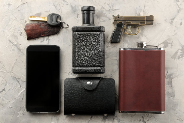 男人的配件。男人的风格。智能手机，钱包，烧瓶，钥匙，名片，香水在轻混凝土背景。平的。图片下载