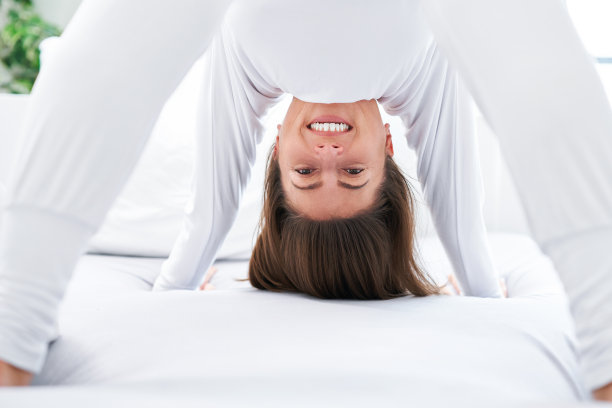 漂亮的女人在床上放松或做瑜伽图片下载