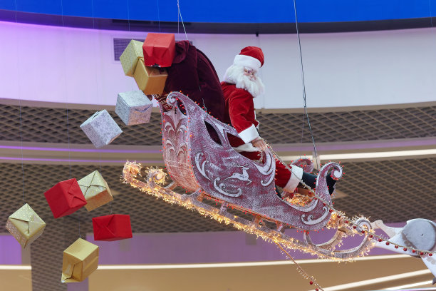 圣诞老人坐在雪橇上，礼物从雪橇上掉下来。圣诞节和新年的概念图片下载
