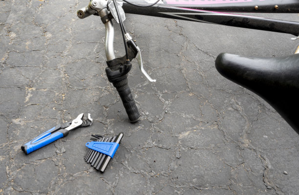旧自行车和螺丝刀放在旁边的地上。坏了的自行车可以修理了图片下载