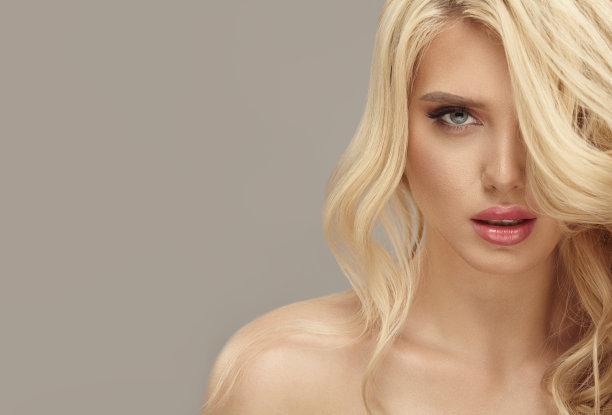 工作室美丽的欧洲女人与健康的金发长波浪头发孤立的背景图片图片下载