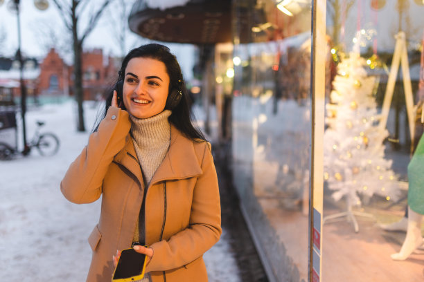 美丽的年轻女子喜欢在城市里听音乐图片下载