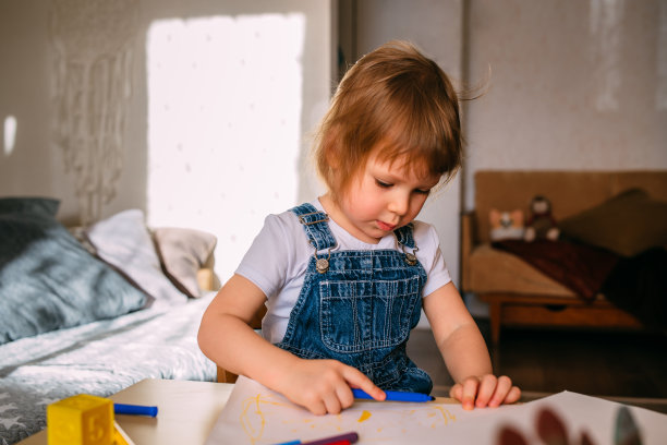 小孩子在家里的儿童桌上用毡头笔画画。图片下载