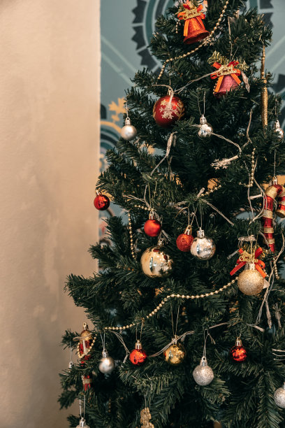 圣诞快乐，近距离彩色球，礼品盒和圣诞祝福图片包裹，铃铛装饰在绿色圣诞树背景装饰在圣诞节和新年。图片下载