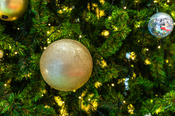 圣诞快乐，近距离彩色球，礼品盒和圣诞祝福图片包裹装饰在绿色圣诞树背景装饰在圣诞节和新年。图片下载