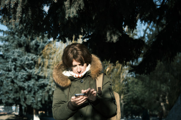 女子在冬季小镇使用智能手机图片下载