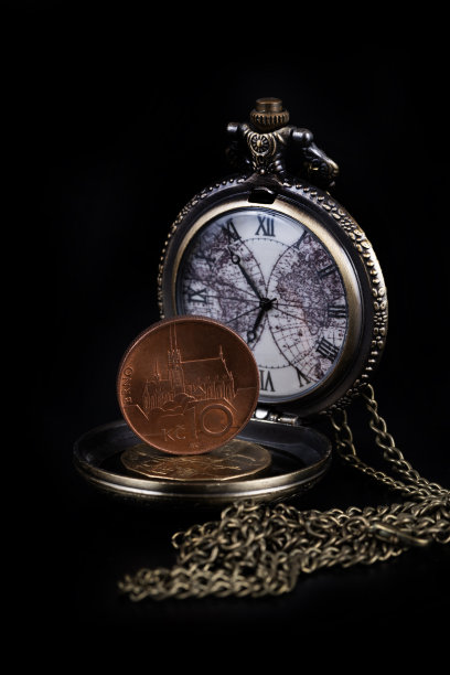 捷克硬币和黑色背景上有链子的古董钟图片下载