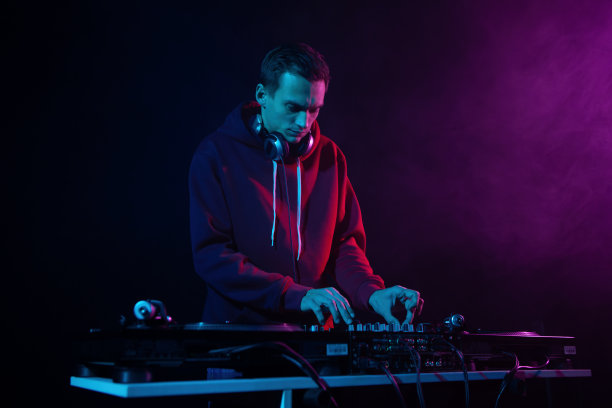 嘻哈派对DJ用混音器和唱盘播放黑胶音乐。俱乐部唱片师在烟雾中混合音乐曲目图片下载