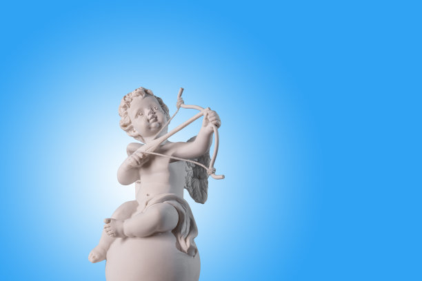 天使丘比特的雕像在讲台上与红心在一个非常紫色的背景。情人节。图片下载