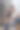 身穿白色t恤和牛仔裤的年轻女子拿着相机看着屏幕，对拍摄结果感到满意。女摄影师坐在椅子上检查相机屏幕上的照片。图片下载