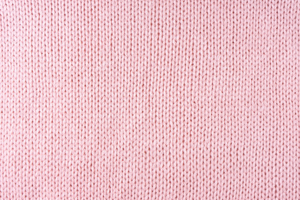 亮粉色针织羊毛面料纹理背景。抽象纺织背景图片下载