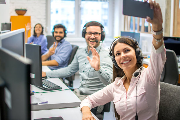 美女客服接线员在呼叫中心为她的团队同事自拍。图片下载