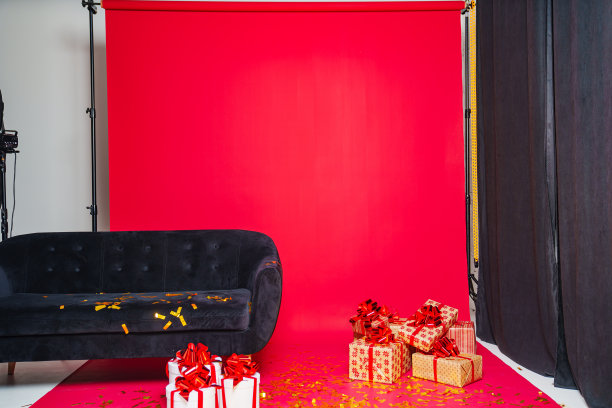 女人在圣诞老人帽子与香槟在照相馆与红色背景。后台。图片下载