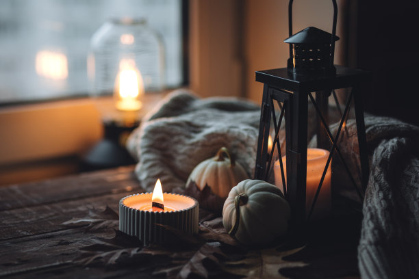 芬芳的蜡烛，南瓜，羊毛衫，树叶，肉桂组成舒适的秋天。在一个灰色的秋天的早晨，芳香疗法，舒适和放松的家庭气氛。木质背景特写。图片下载